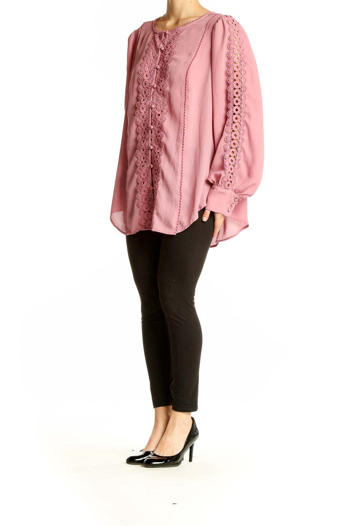 Front view of pink lace-trimmed polyester blouse from Torrid