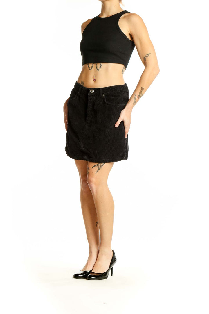 Front view of BDG black corduroy mini skirt with button closure