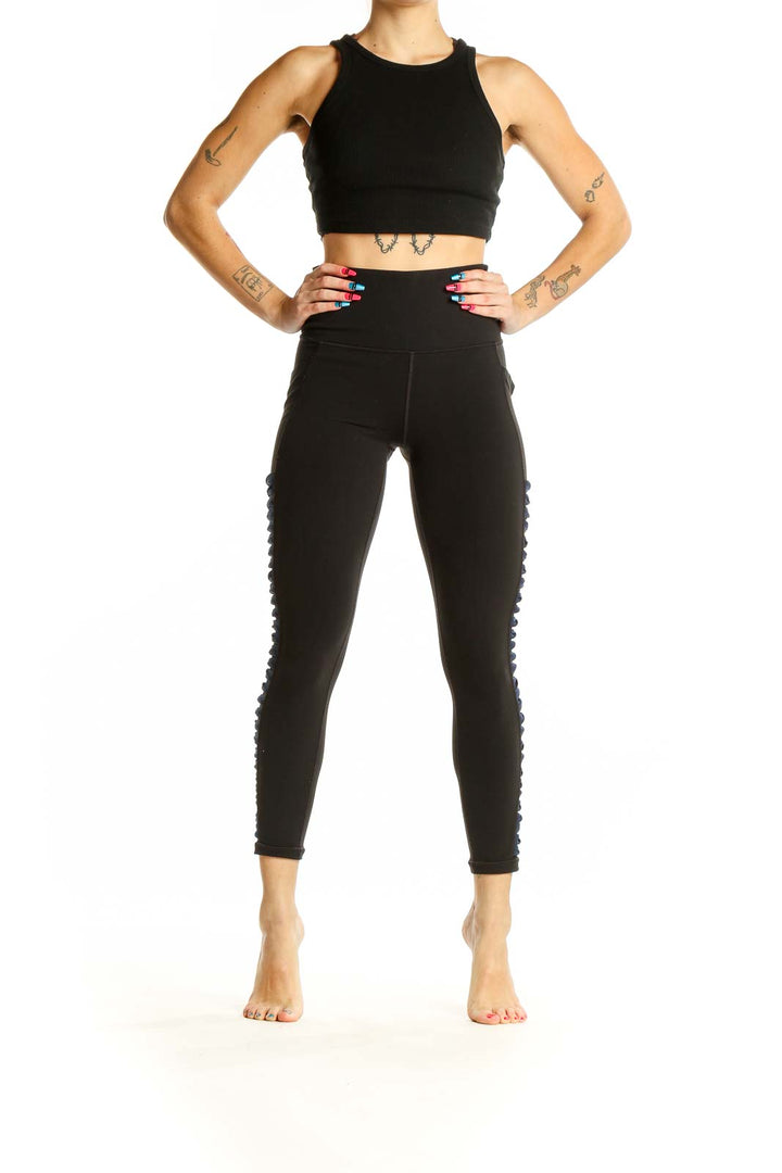 Front view of black Athleta high-waisted leggings with side detailing