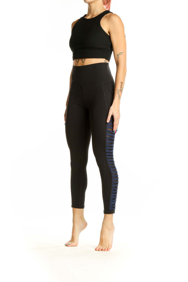 Front view of black Athleta high-waisted leggings with side detailing