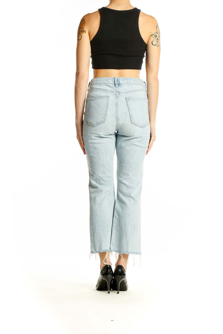 Side view of model wearing Topshop light blue cropped straight-leg jeans with black top