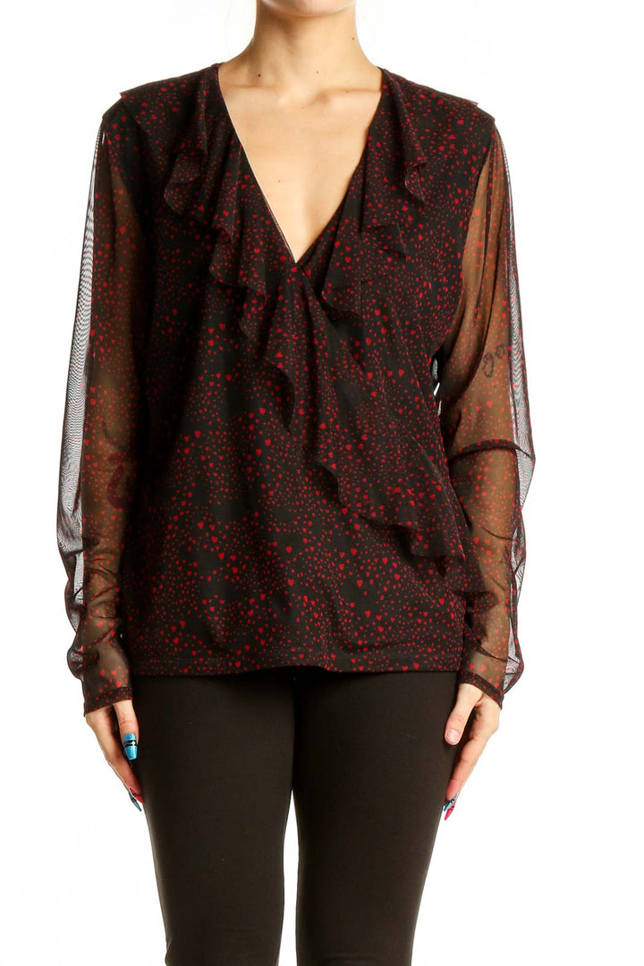 Front view of INC black and red polka dot blouse with ruffled V-neckline