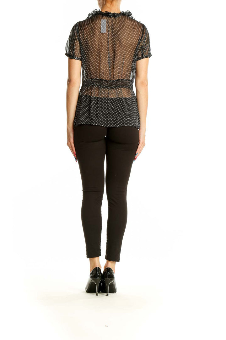 Side view of black sheer polka dot blouse showing translucent fabric and fit