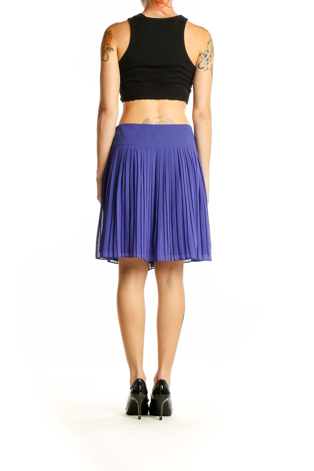 Side view of model wearing LOFT purple pleated mini skirt with black top