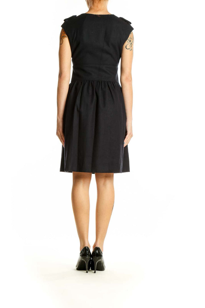 Side view of Club Monaco black fit-and-flare dress showing cap sleeves