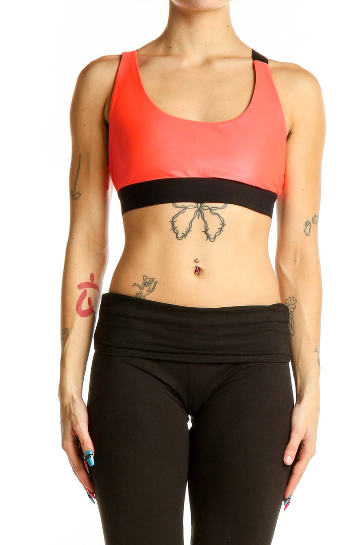 Front view of red KORAL athletic crop top with black band