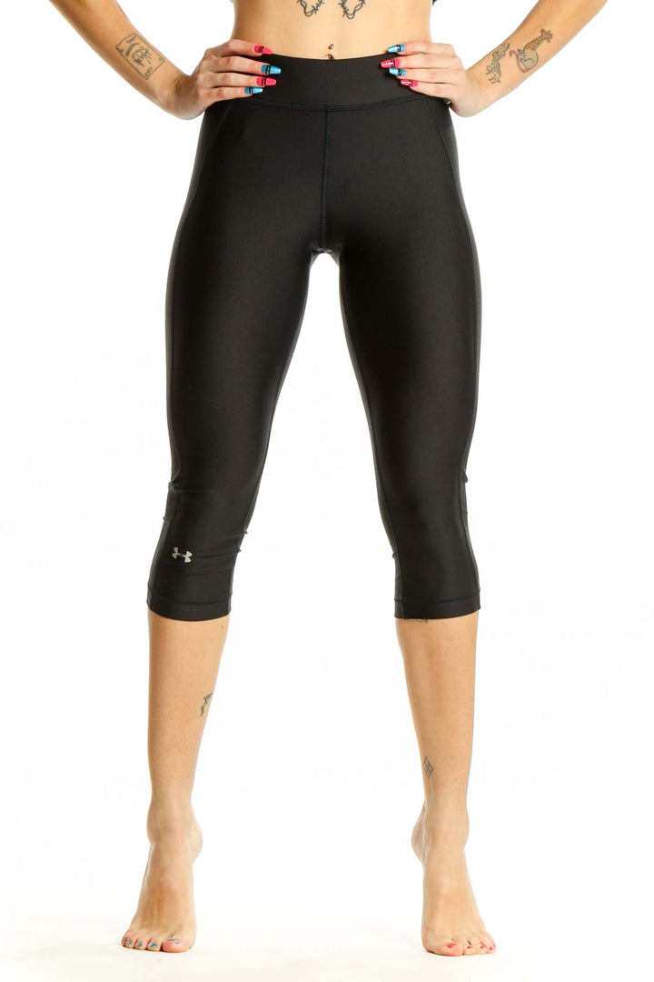 Front view of black Under Armour capri compression leggings on model