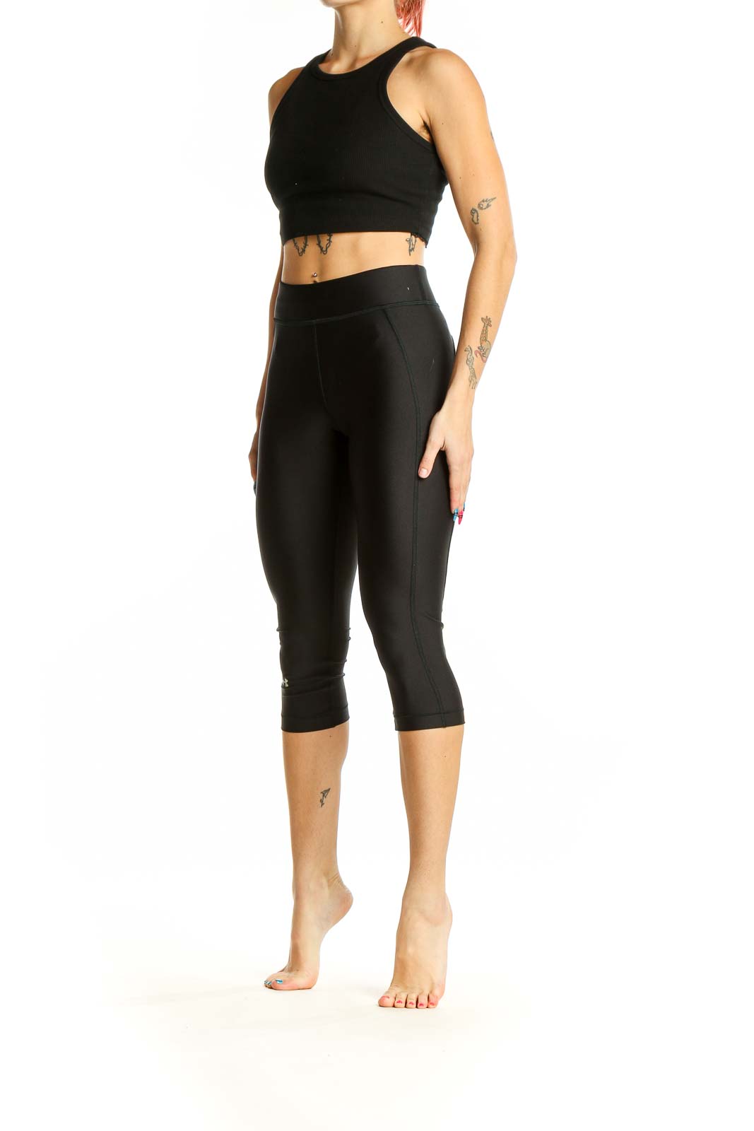 Front view of black Under Armour capri compression leggings on model