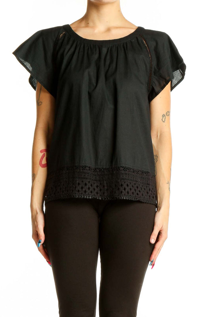 Front view of black flowy top with eyelet trim and flutter sleeves