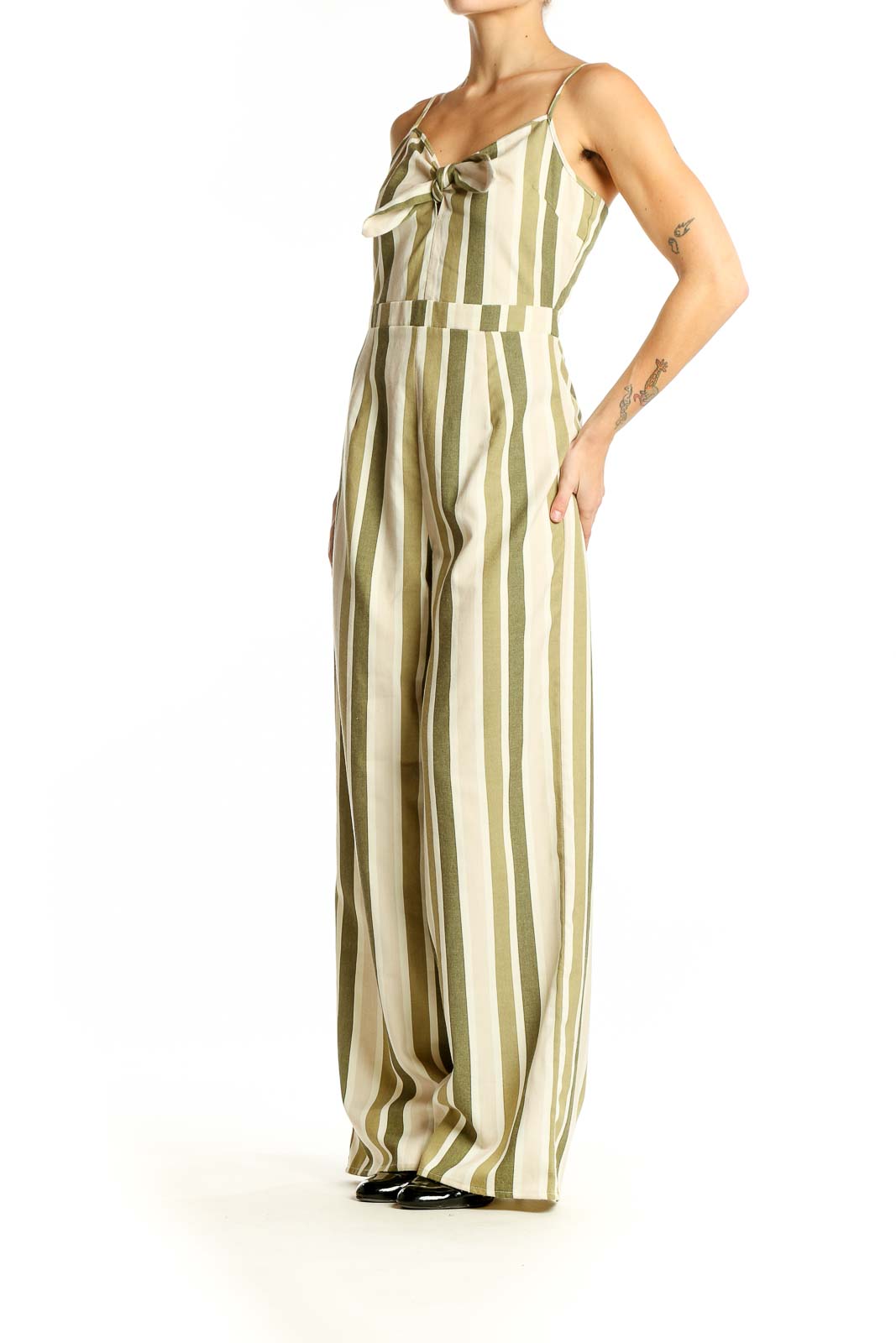 Front view of green and cream striped wide-leg jumpsuit with bow detail