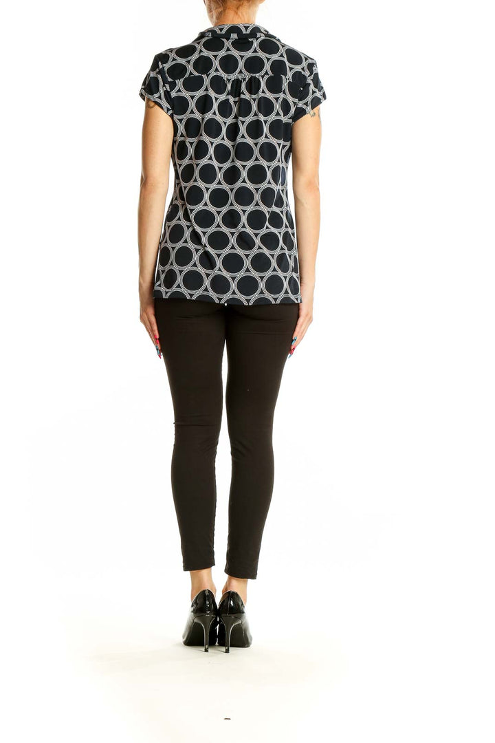 Back view of Alfani black and white geometric print polo top on model