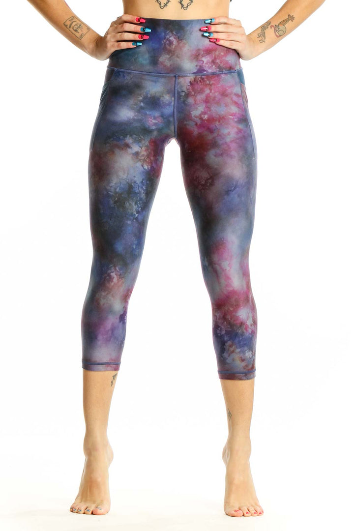 Front view of Athleta cosmic tie-dye capri leggings in blue and pink