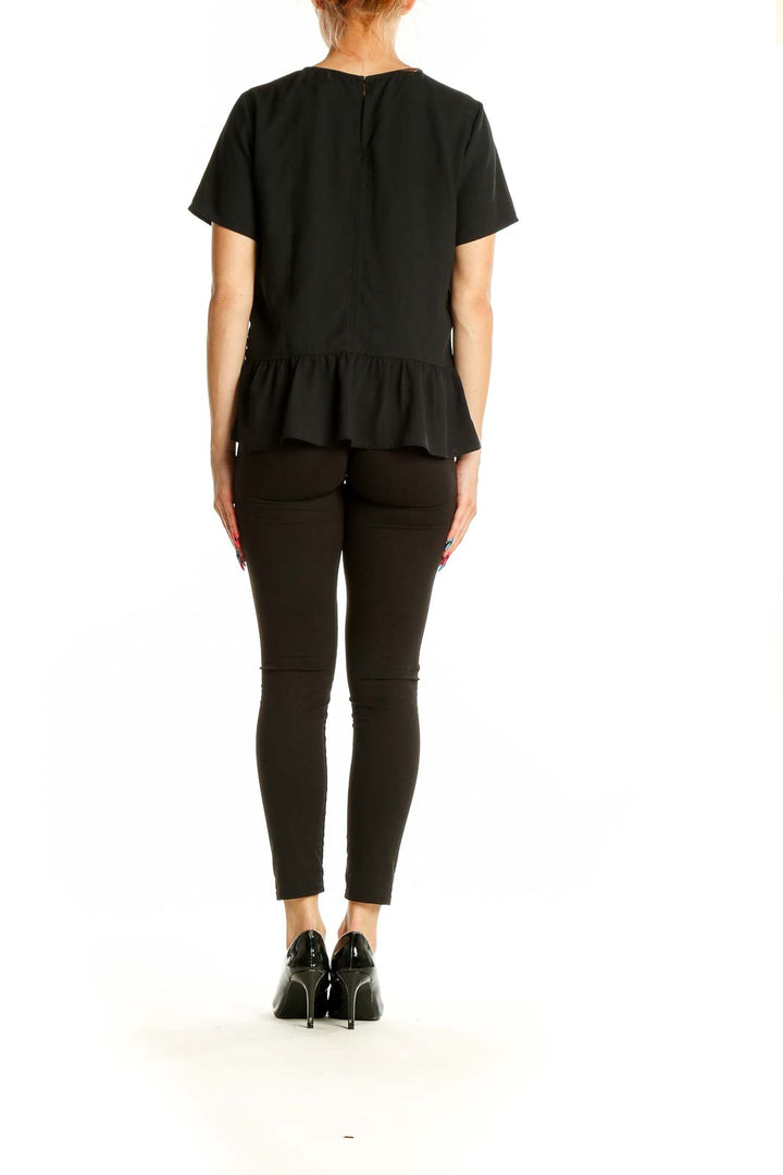 Back view of Ann Taylor black peplum top showing flared hem