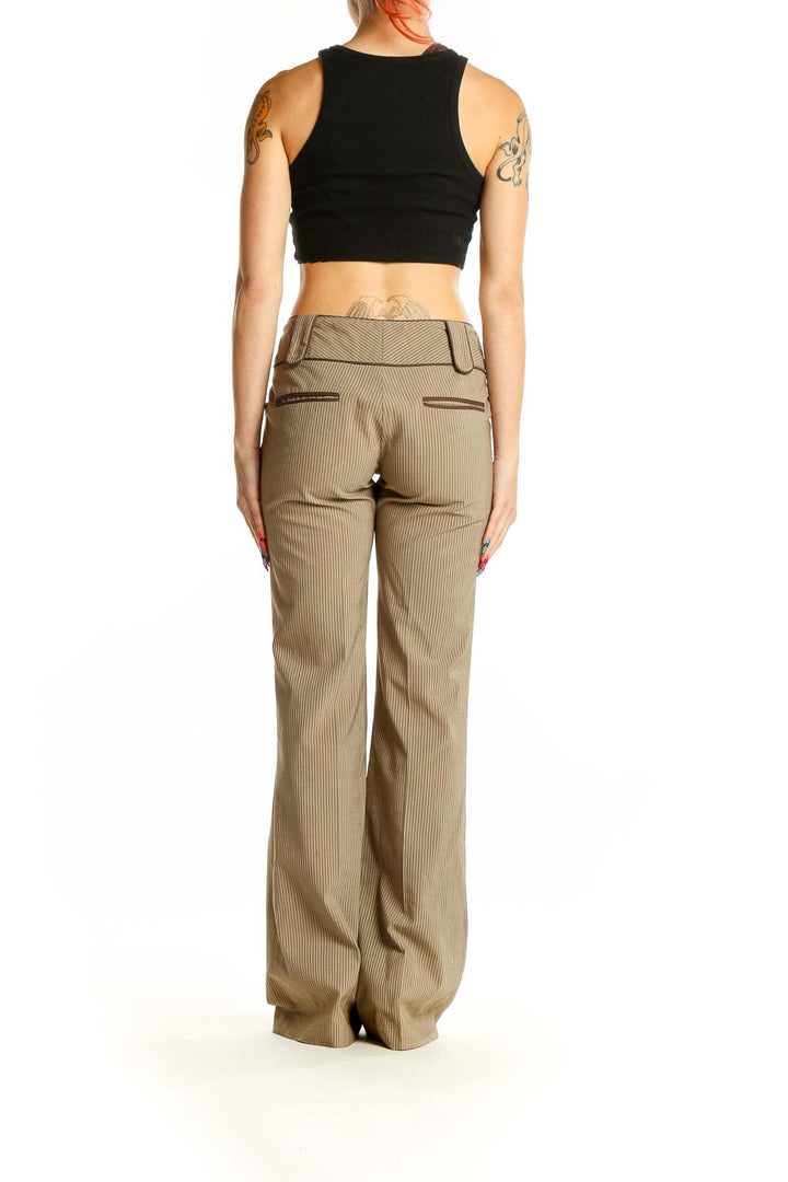 Side view of model wearing Alice + Olivia tan pinstriped wide-leg trousers with black crop top