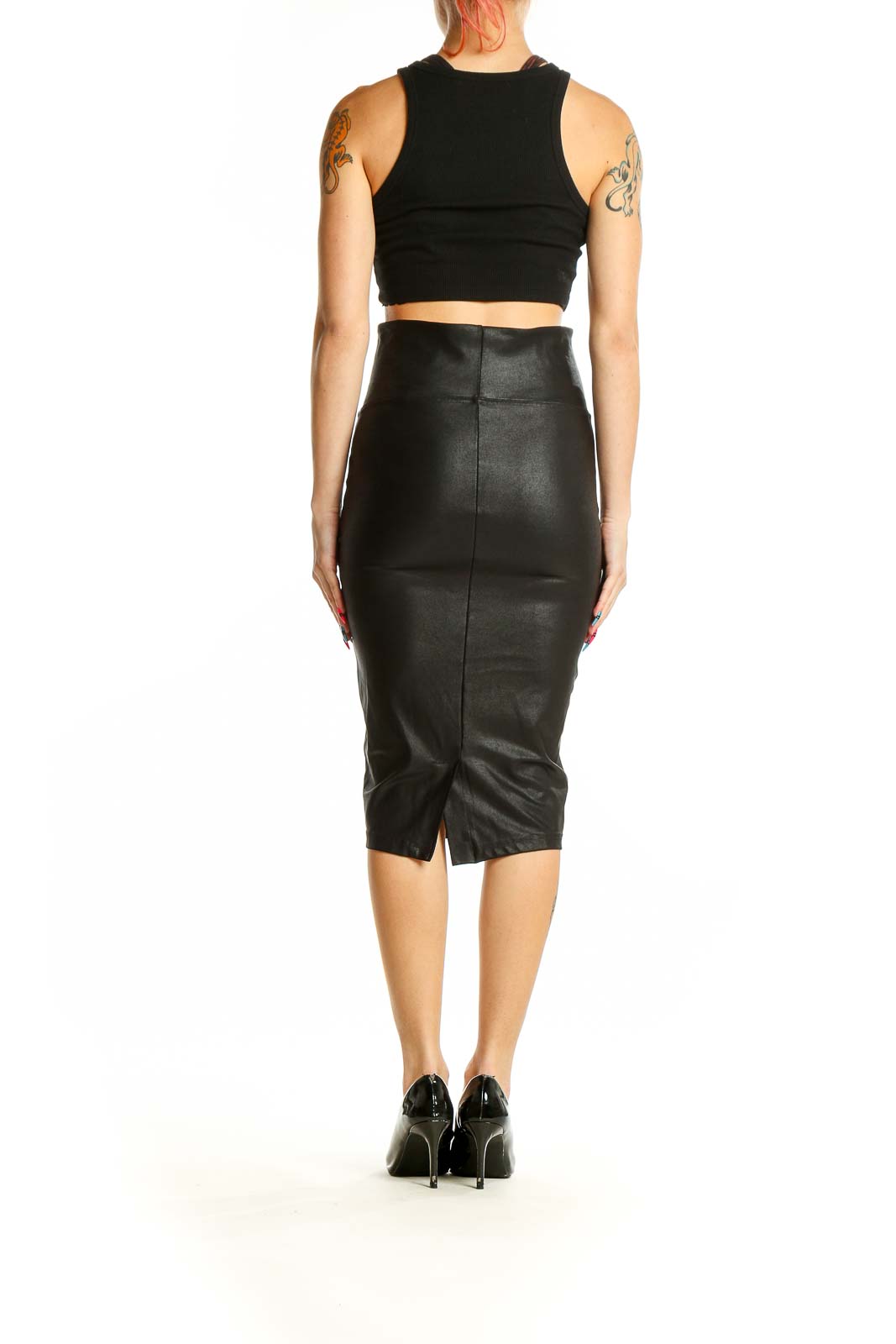 Back view of woman wearing Spanx black faux leather pencil skirt with black crop top