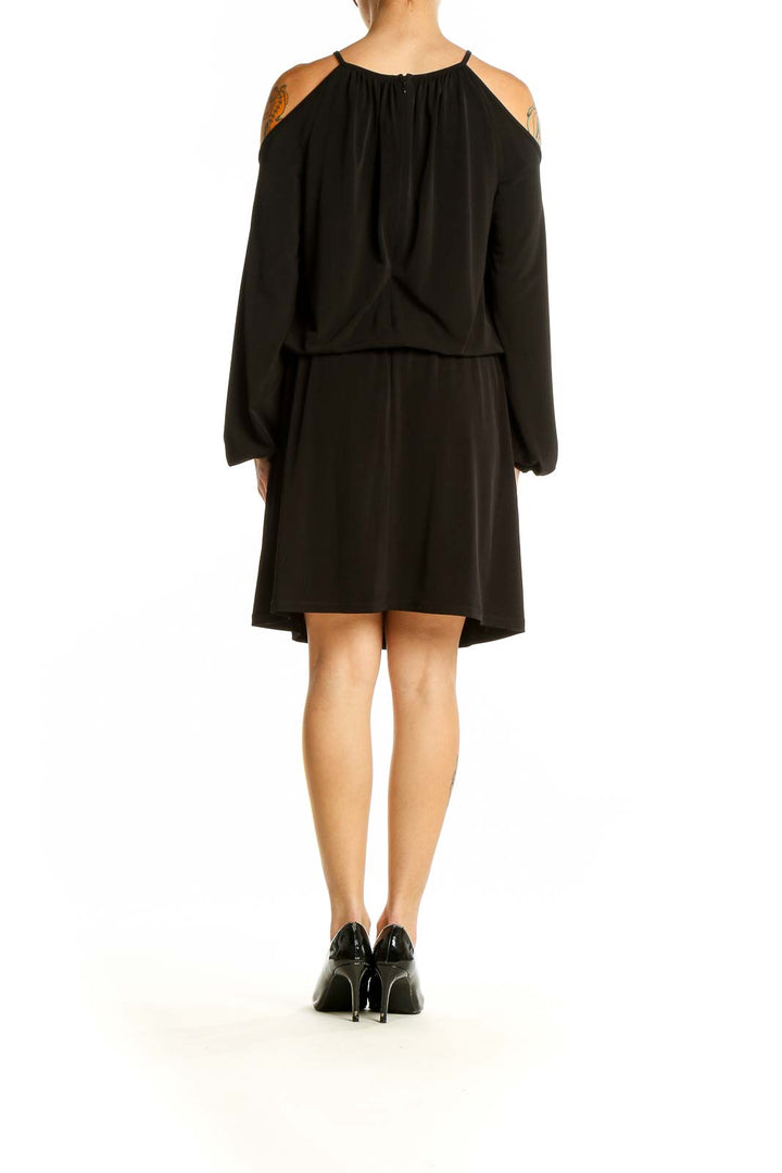 Back view of Michael Kors black cold shoulder blouson dress showing elegant silhouette