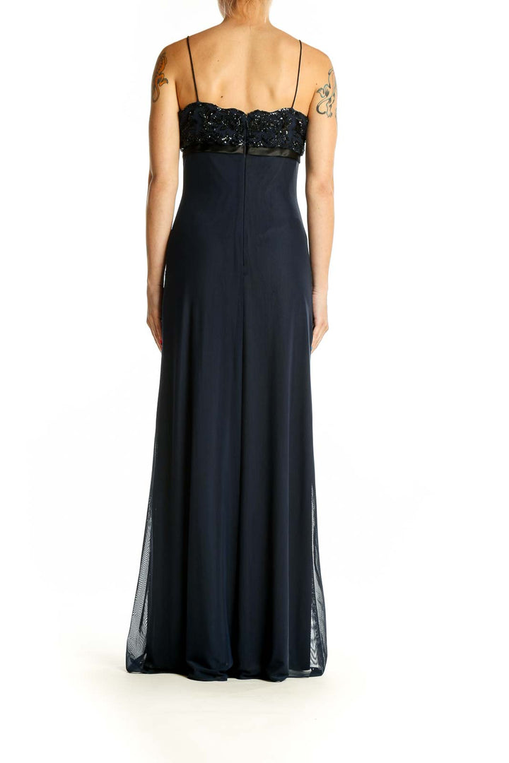 Back view of navy beaded empire waist gown showing flowing silhouette