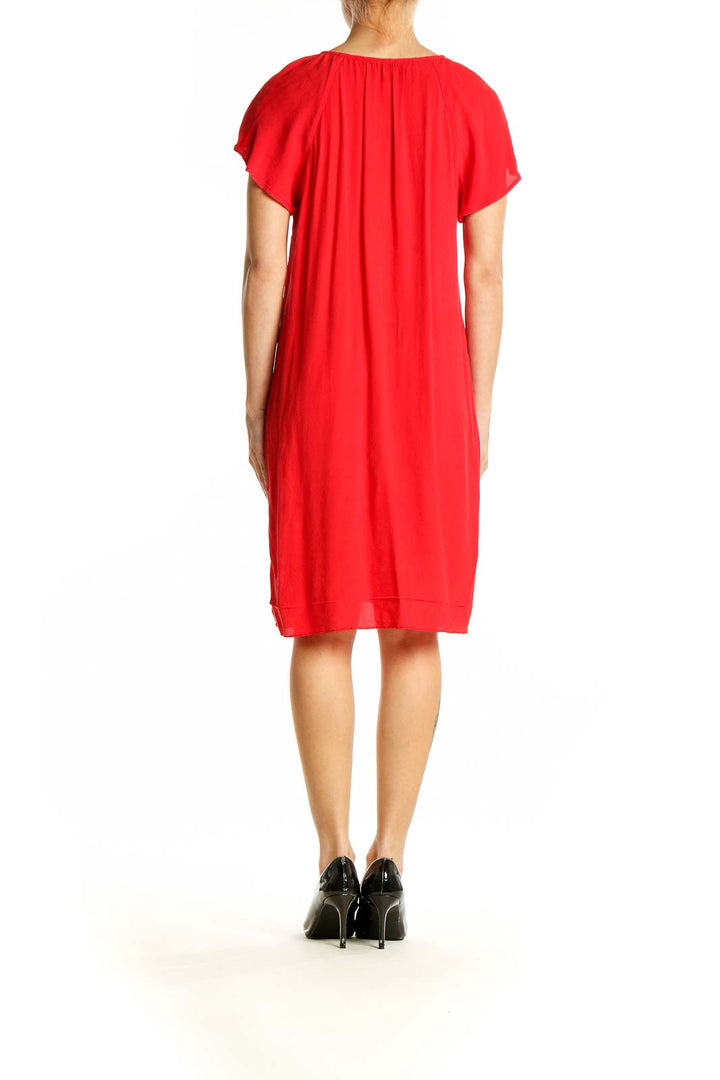 Side view of red Madewell dress showing fluttery short sleeves and knee-length cut