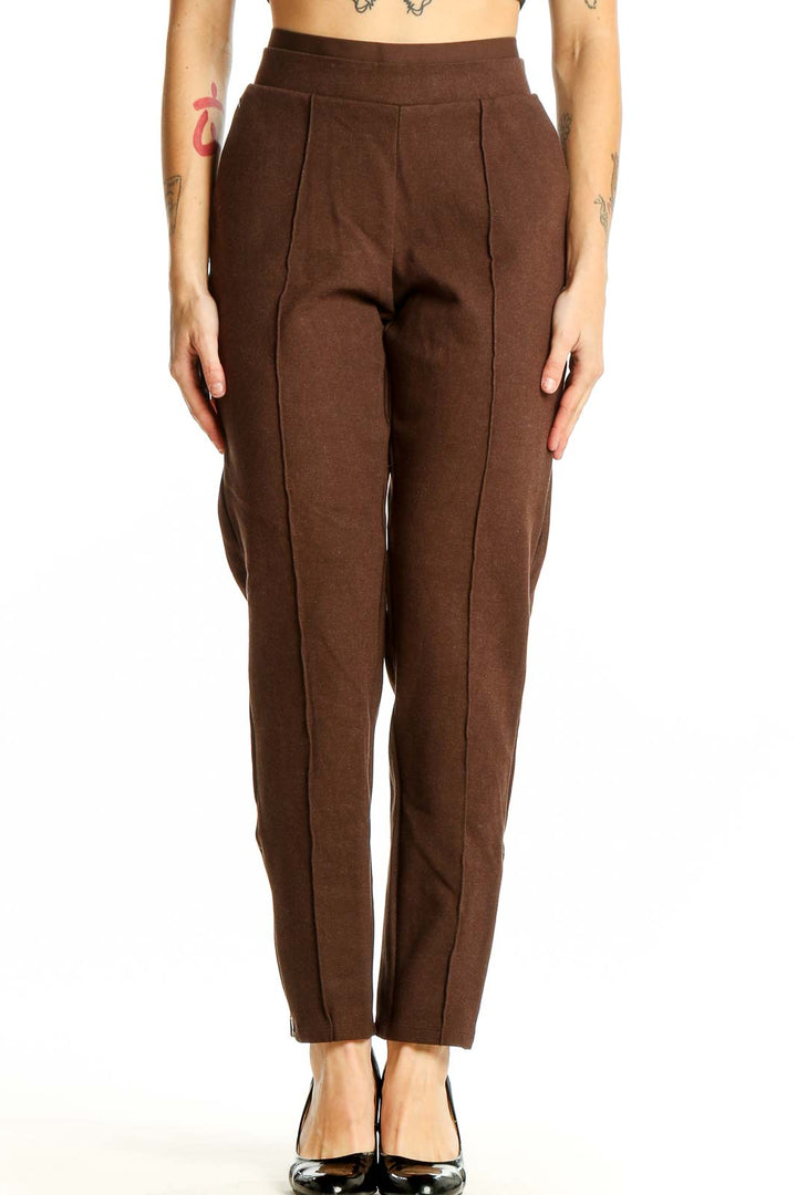 Front view of Athleta brown high-waisted pleated trousers