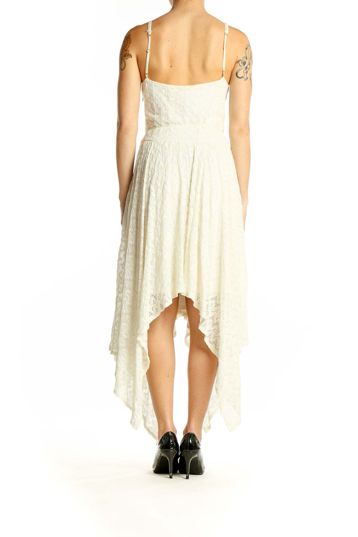 Side view of Bebe ivory lace maxi dress showing handkerchief hem and lace detail