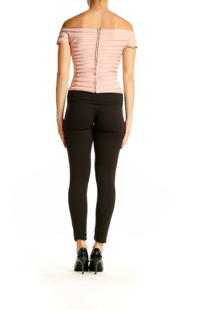 Side view of JS Collections pink striped off-shoulder top with black pants