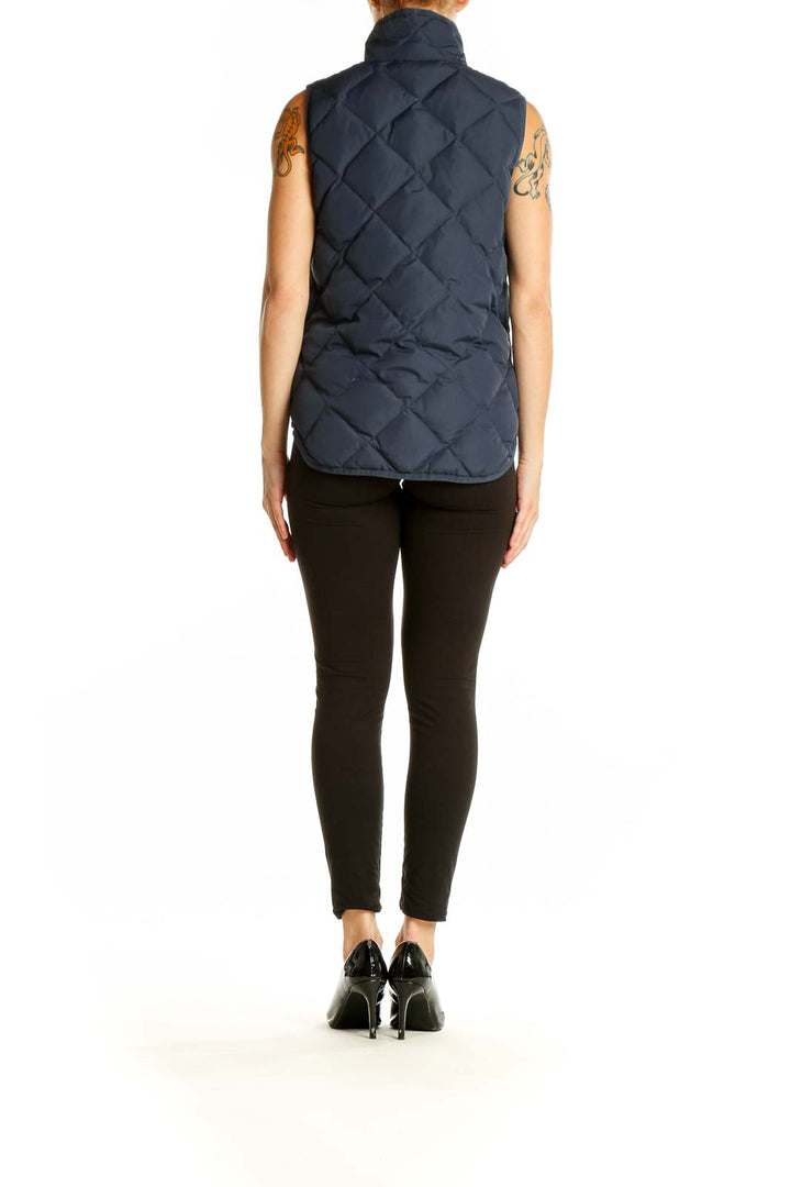 Side view of J.Crew navy quilted puffer vest on model with black pants