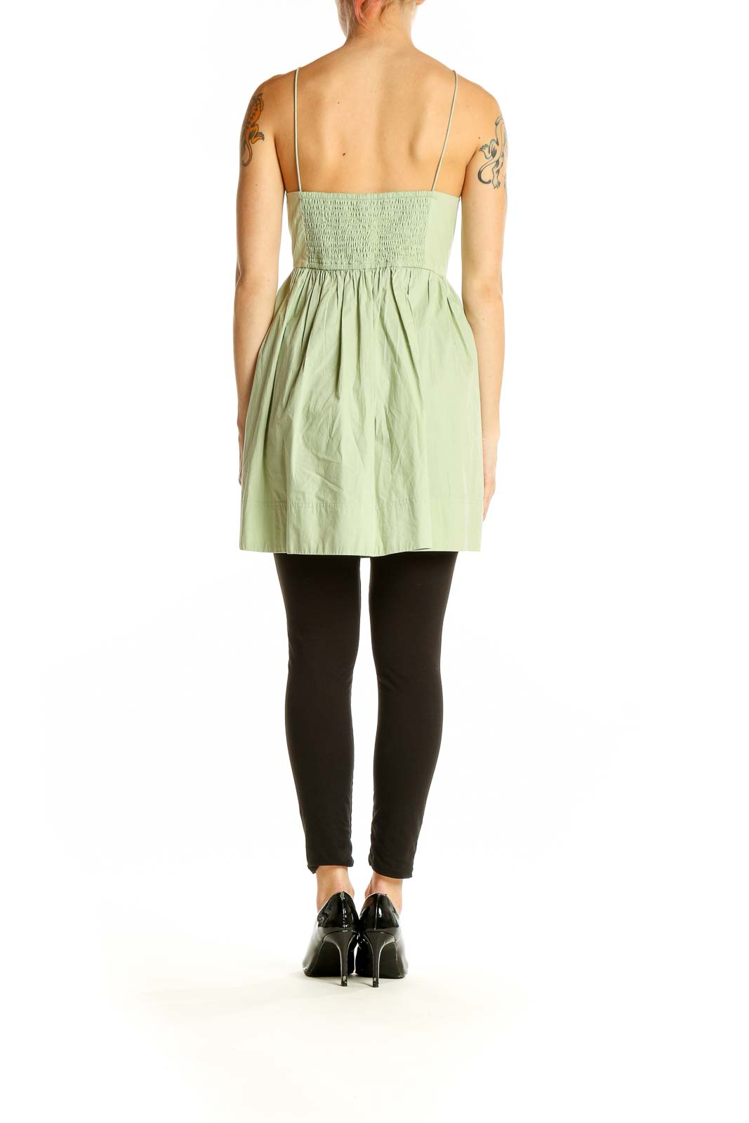 Side view of Maeve sage green cotton babydoll top on model with black pants