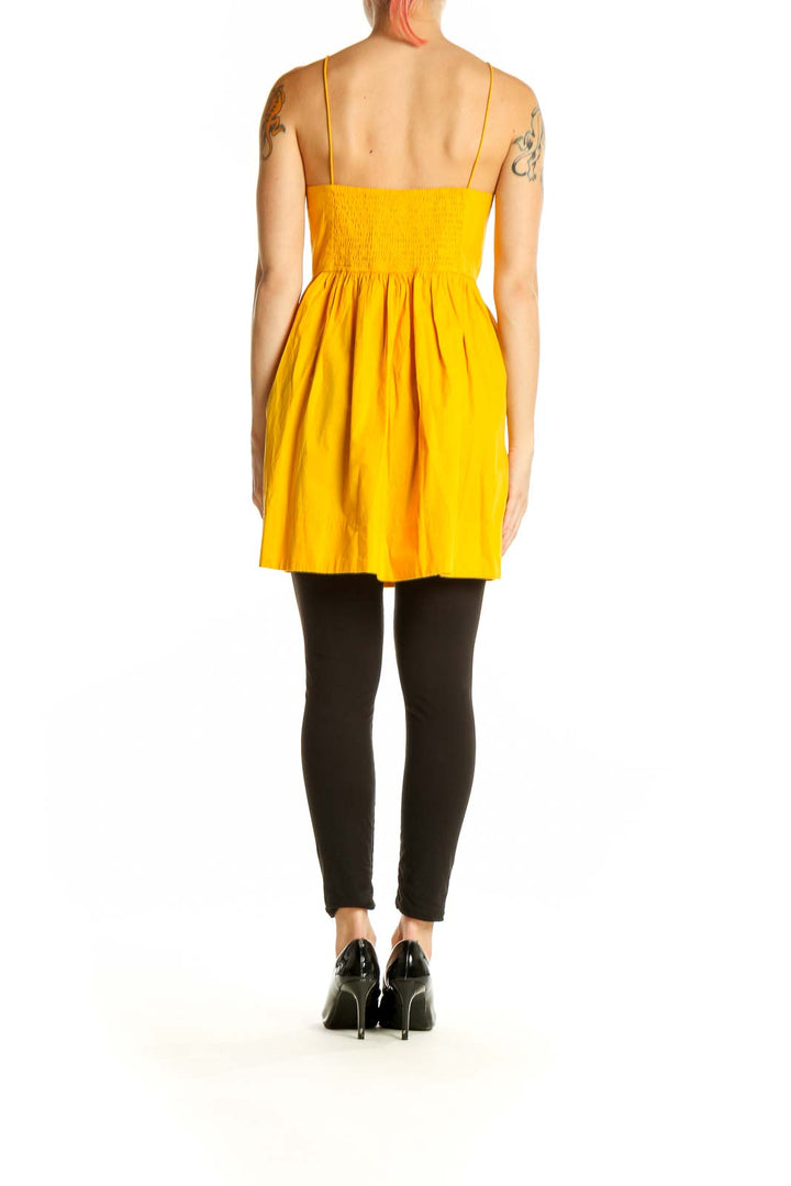 Side view of yellow cotton sundress showing gathered skirt and empire waist