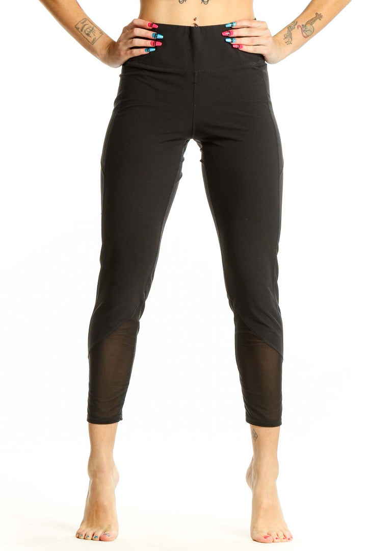 Front view of black Athleta cropped activewear leggings with mesh panels