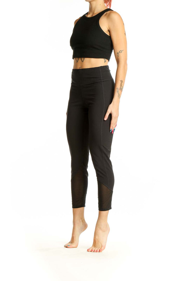 Front view of black Athleta cropped activewear leggings with mesh panels