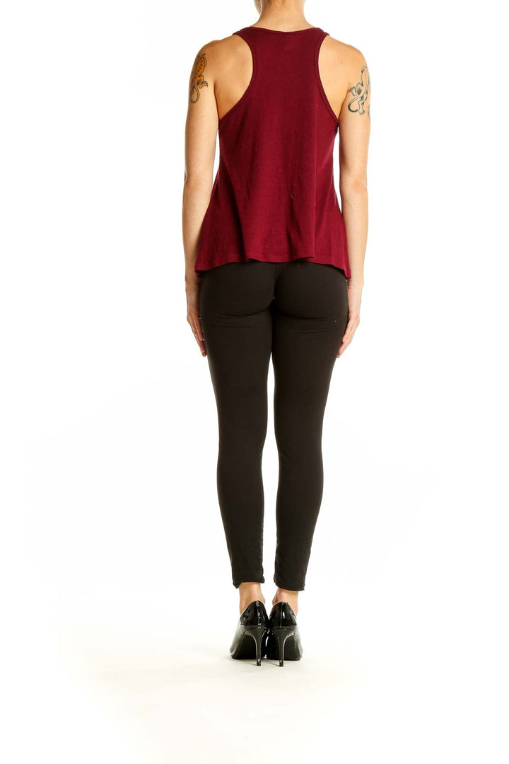 Side view of model wearing burgundy Free People tank top with black pants