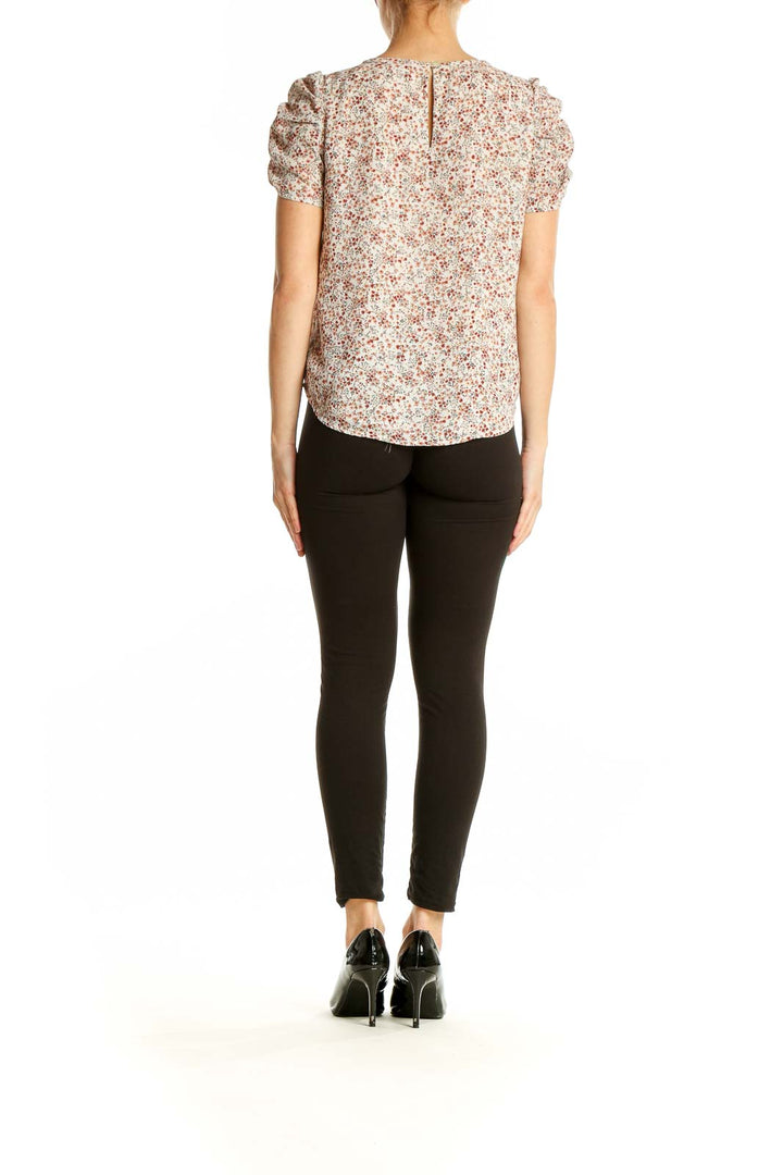 Side view of model wearing LOFT cream floral puff sleeve blouse with black pants