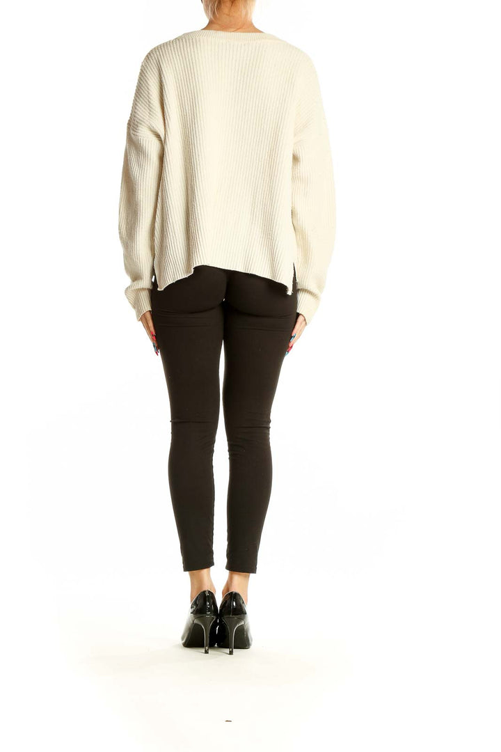 Side view of cream ribbed knit sweater showing relaxed fit and texture