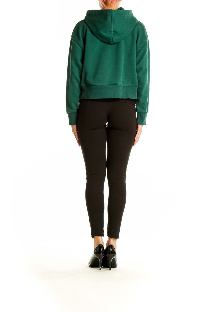 Side view of model wearing green cropped Zara hoodie with black pants