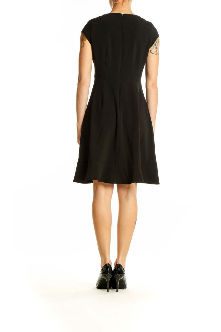 Back view of black Banana Republic cap sleeve dress showing flared skirt