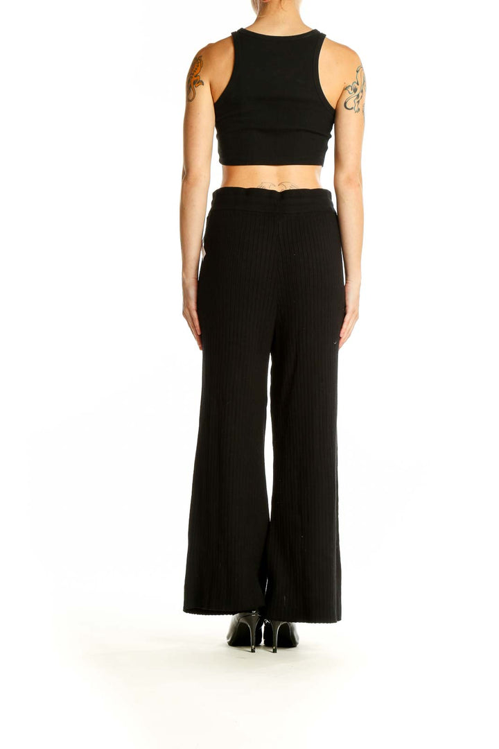 Side view of model wearing Victoria's Secret black wide-leg lounge pants with crop top