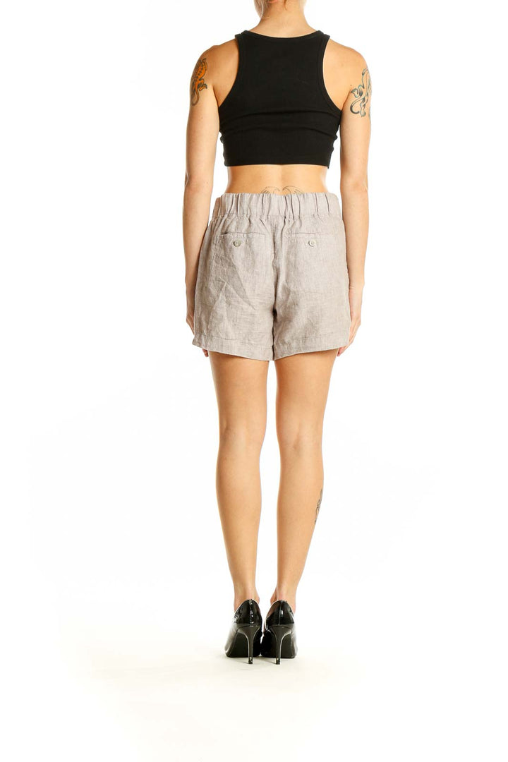 Side view of model wearing Athleta beige linen shorts with black top