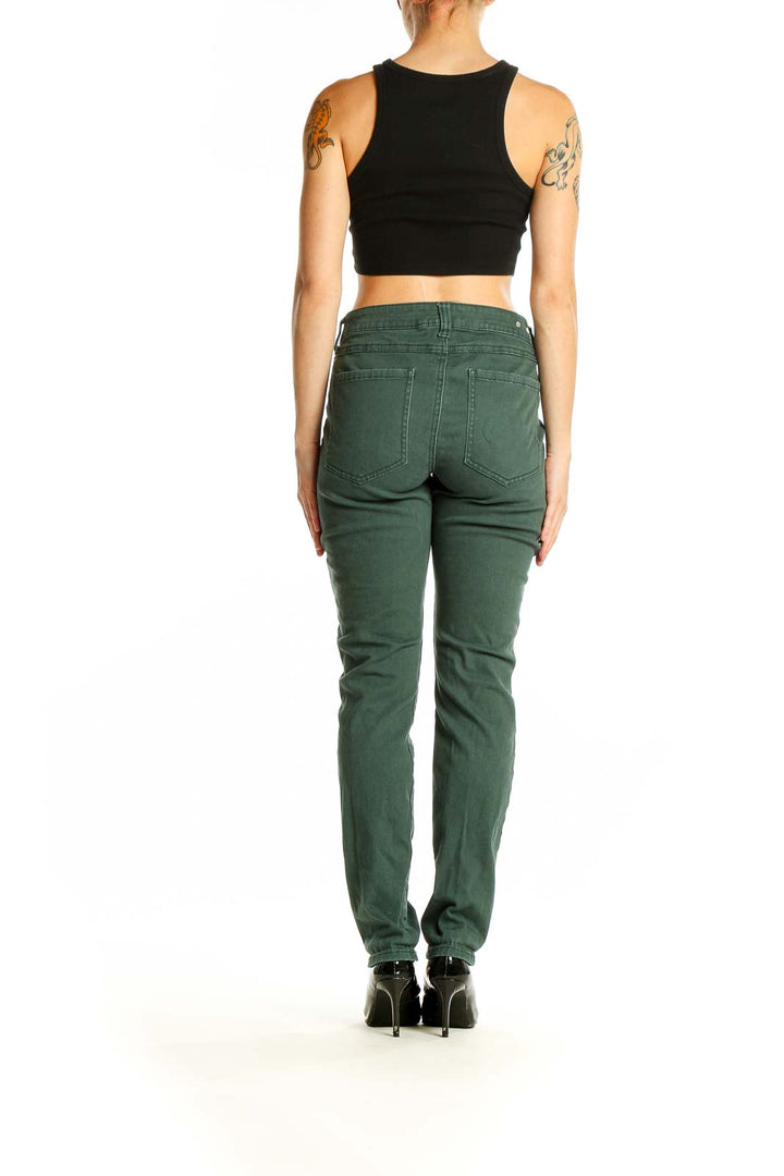 Side view of woman wearing Cabi green slim fit denim jeans