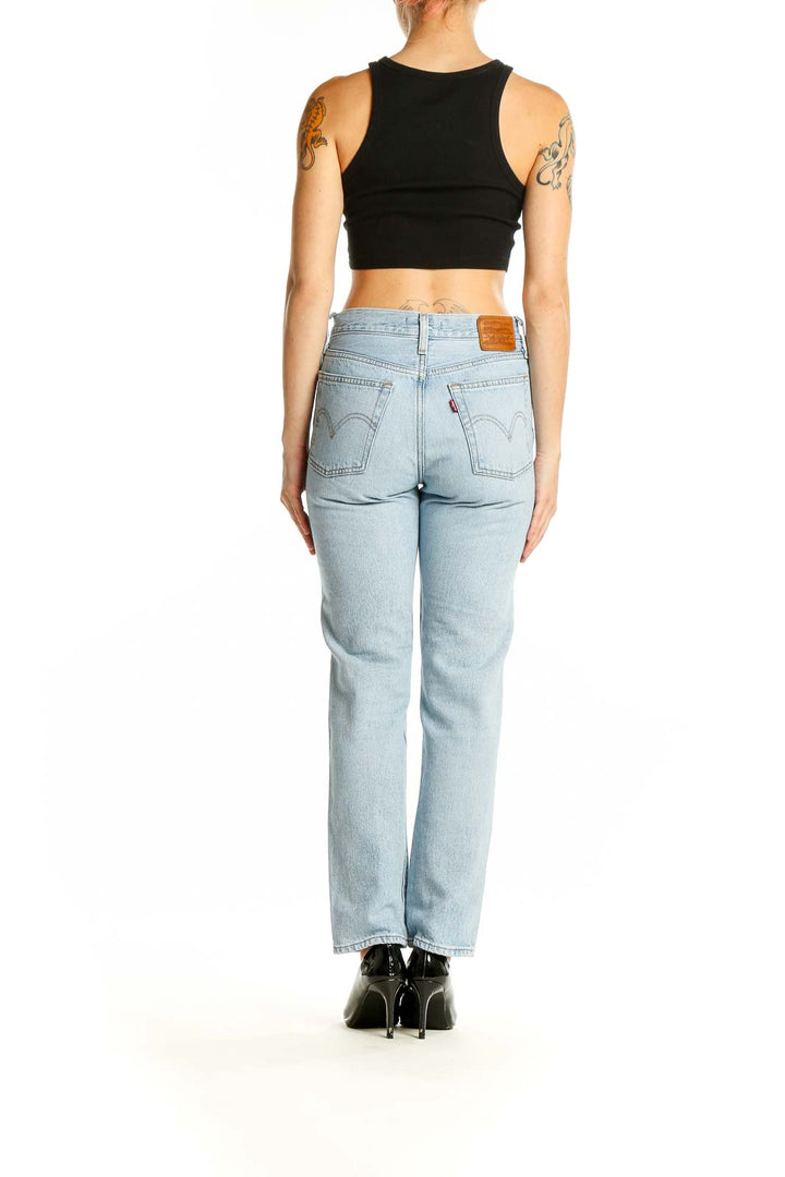 Back view of Levi's light blue straight leg jeans on model with black crop top