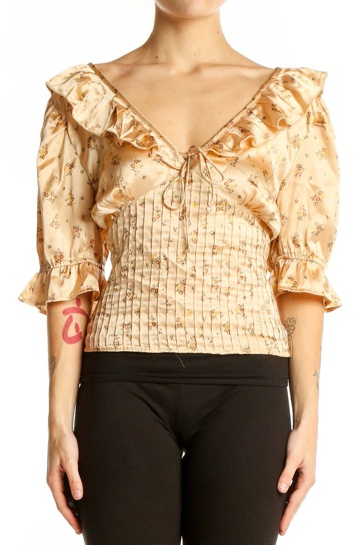 Front view of beige floral Free People top with ruffled V-neck and puff sleeves