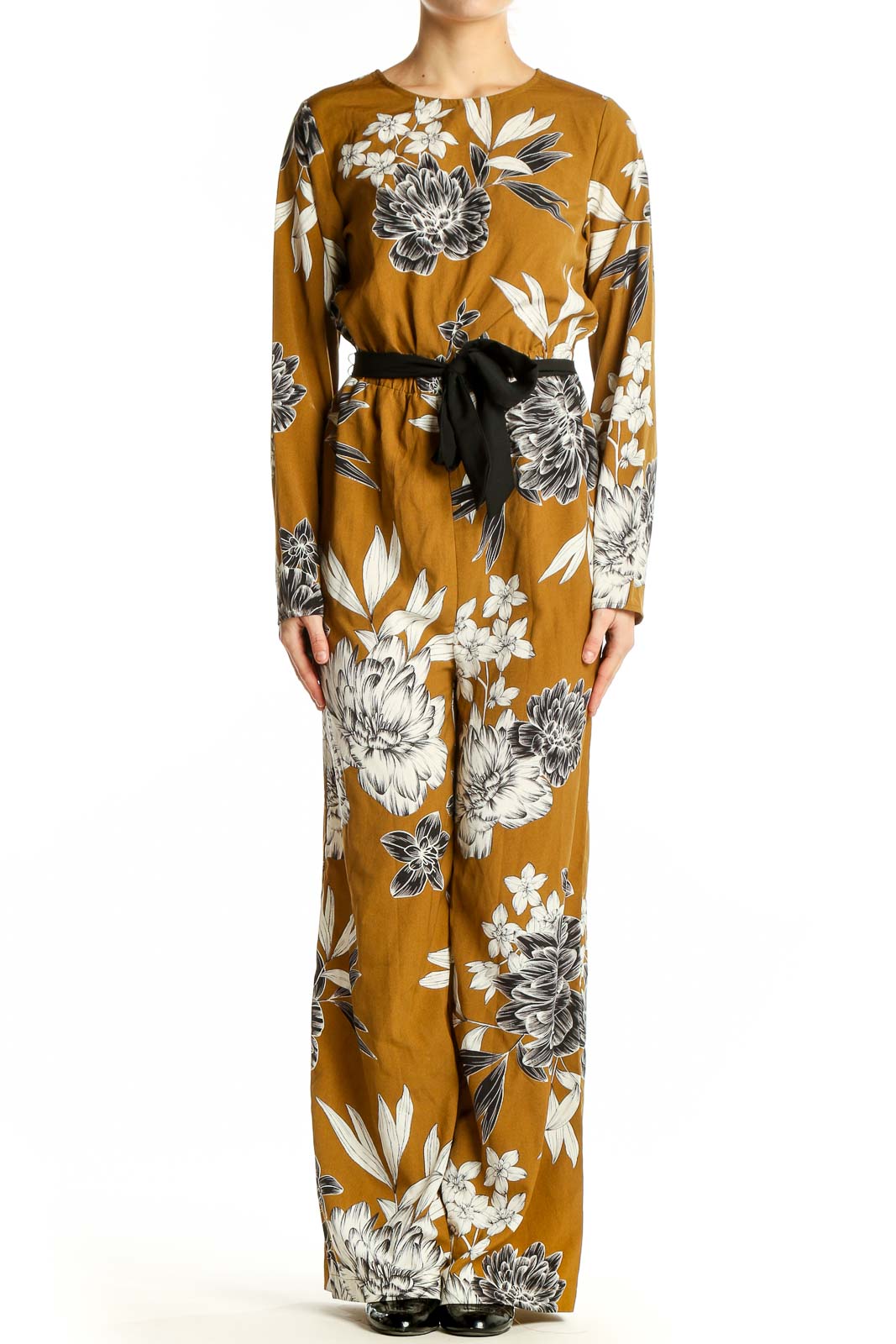 Front view of SilkRoll mustard floral long sleeve jumpsuit with black belt