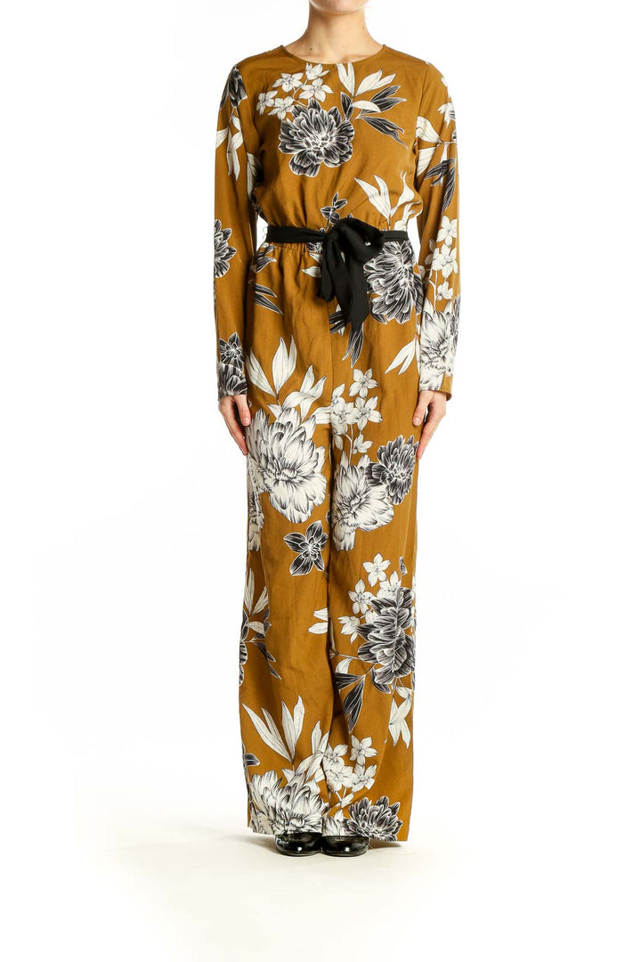 Front view of SilkRoll mustard floral long sleeve jumpsuit with black belt