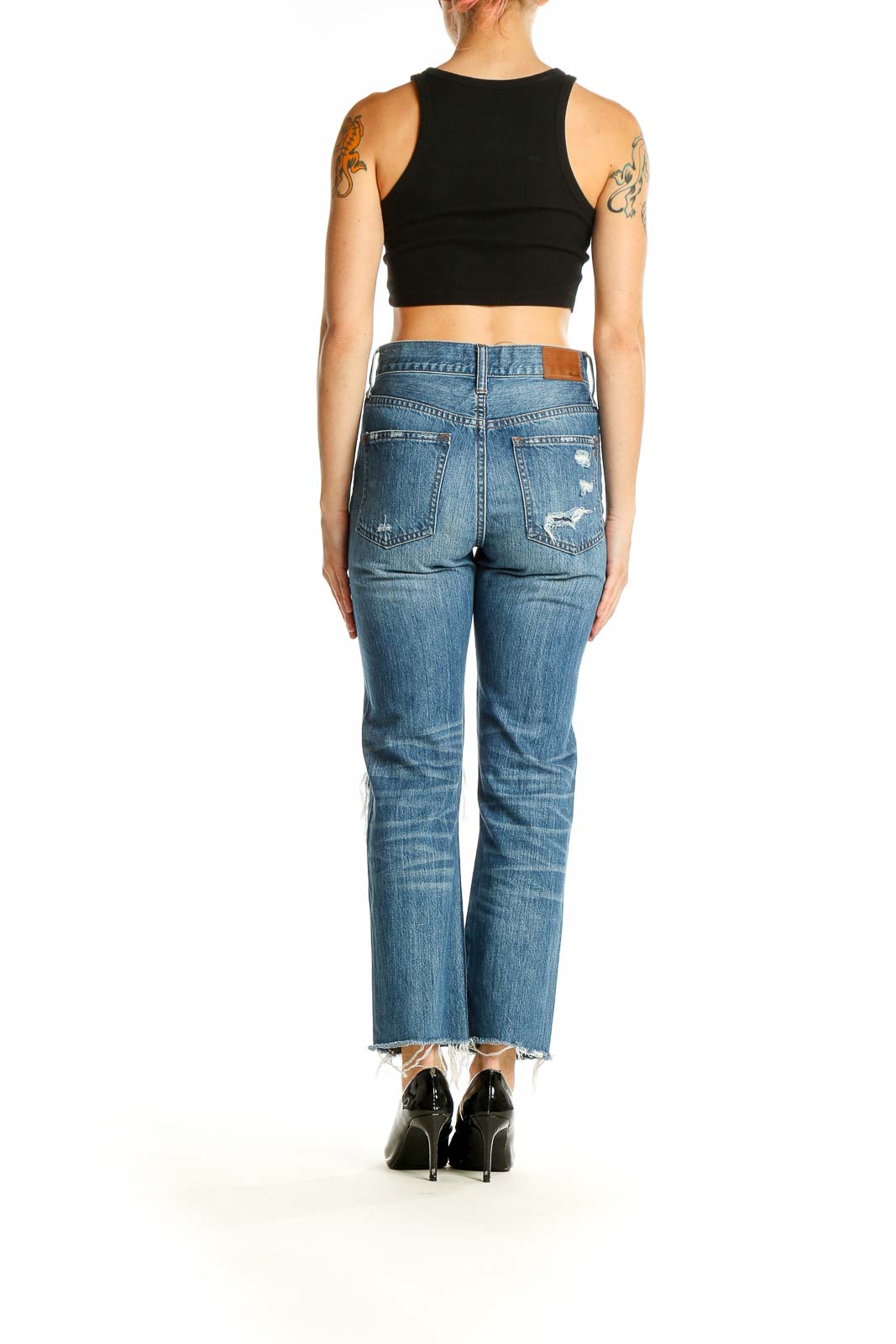 Side view of model wearing Madewell blue distressed straight leg jeans