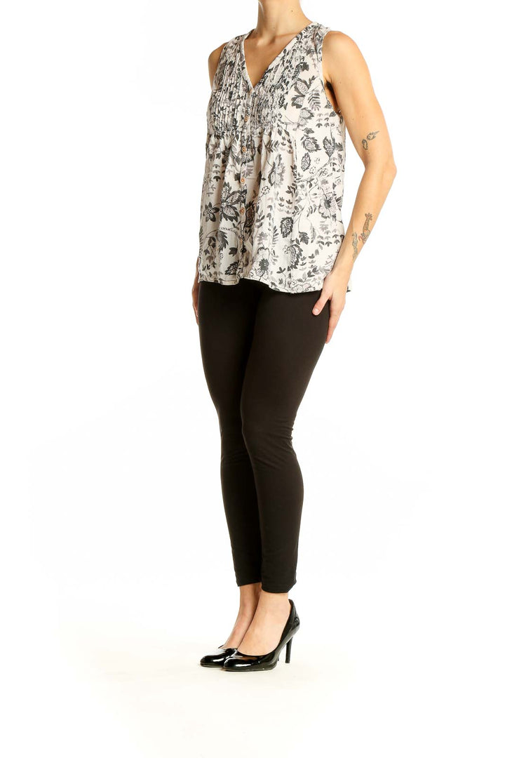 Front view of Maeve white sleeveless top with gray floral print and button-front closure