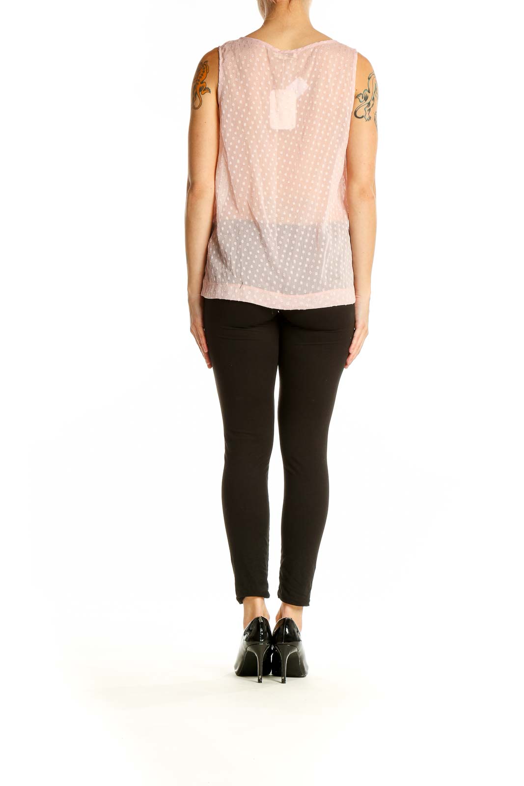 Side view of model wearing Millau pink sheer polka dot tank top with black pants