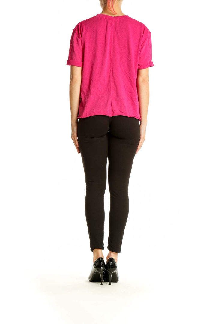 Side view of WE THE FREE hot pink oversized t-shirt on model with black pants