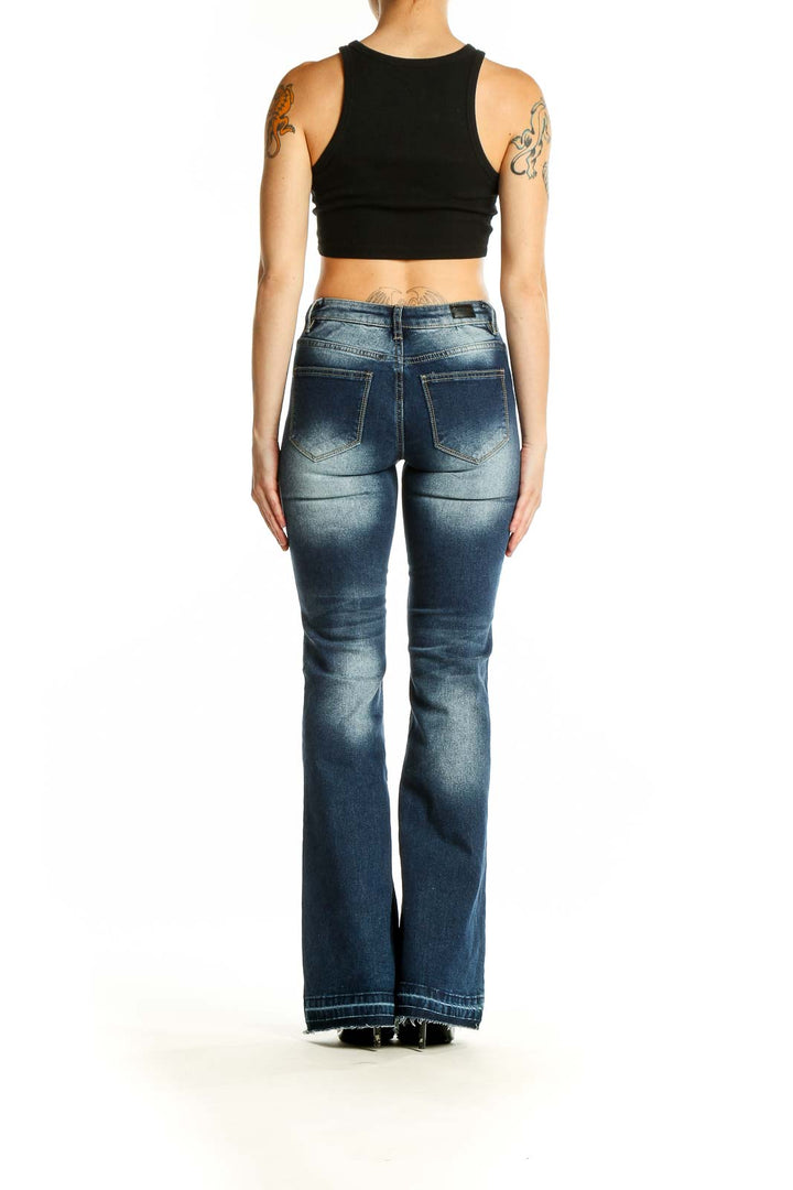 Back view of Flamingals blue faded flare jeans on model