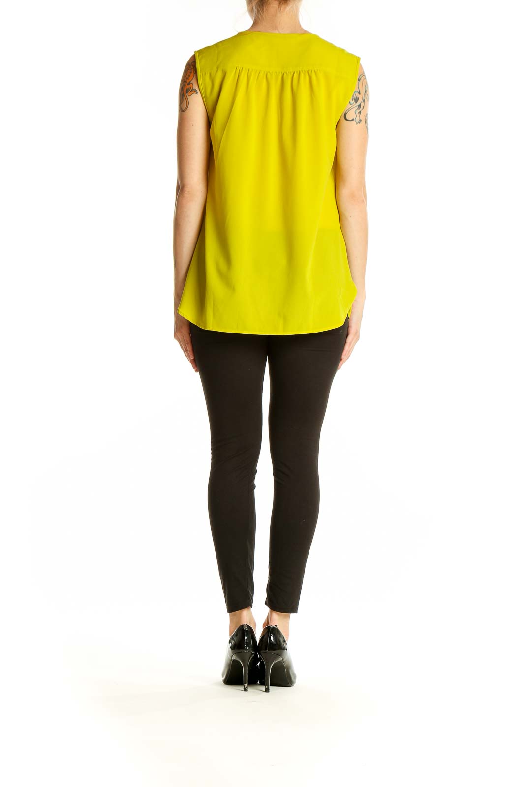 Side view of model wearing J.Crew yellow sleeveless polyester blouse with black pants