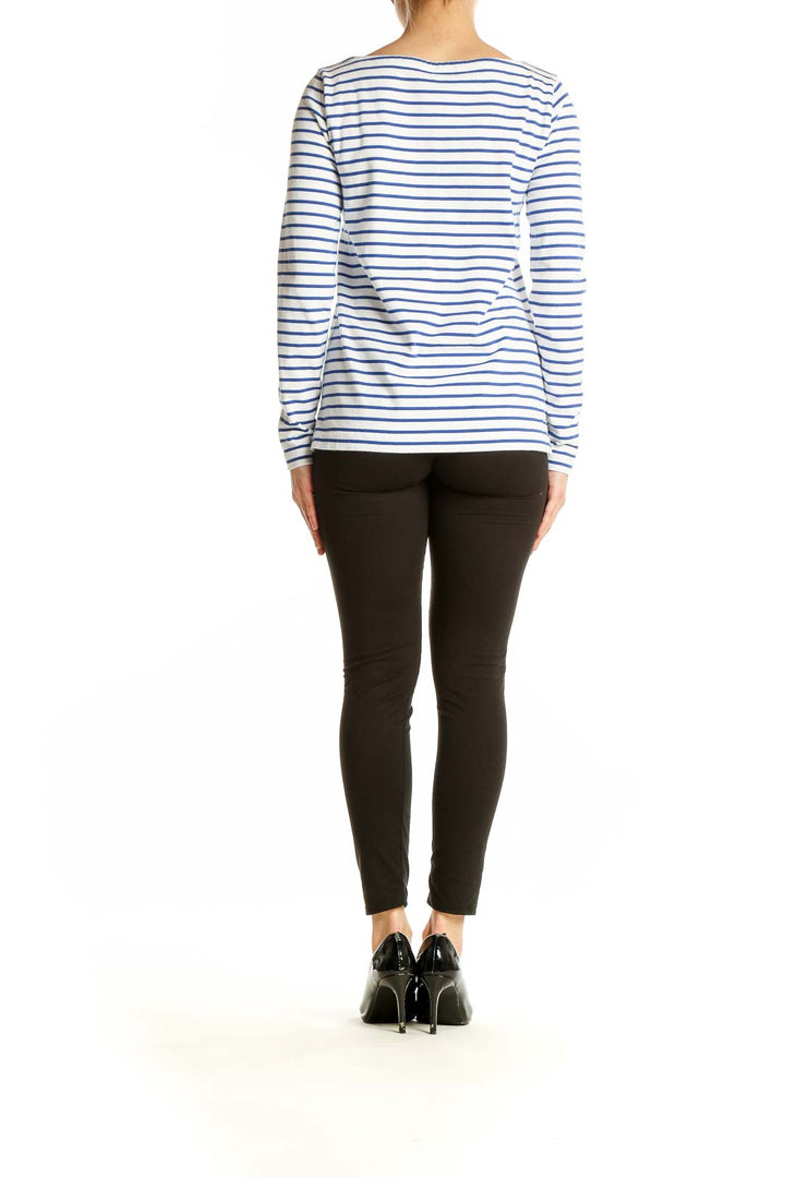 Side view of J.Crew blue and white striped long-sleeve cotton top on model with black pants