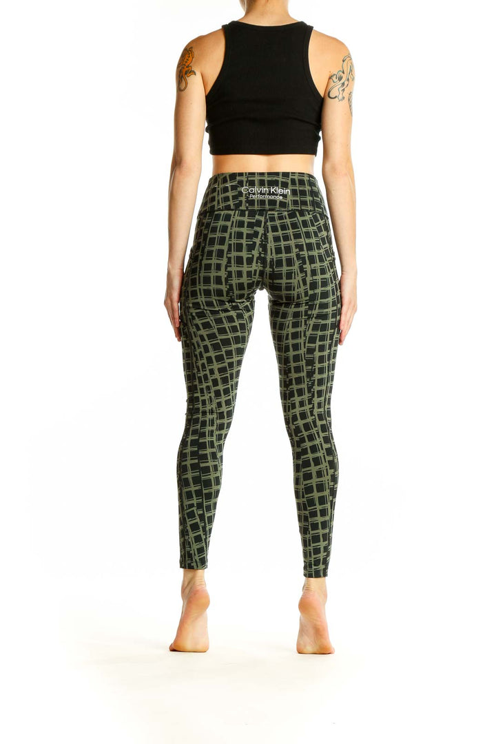 Side view of woman wearing olive green Calvin Klein activewear leggings with geometric print